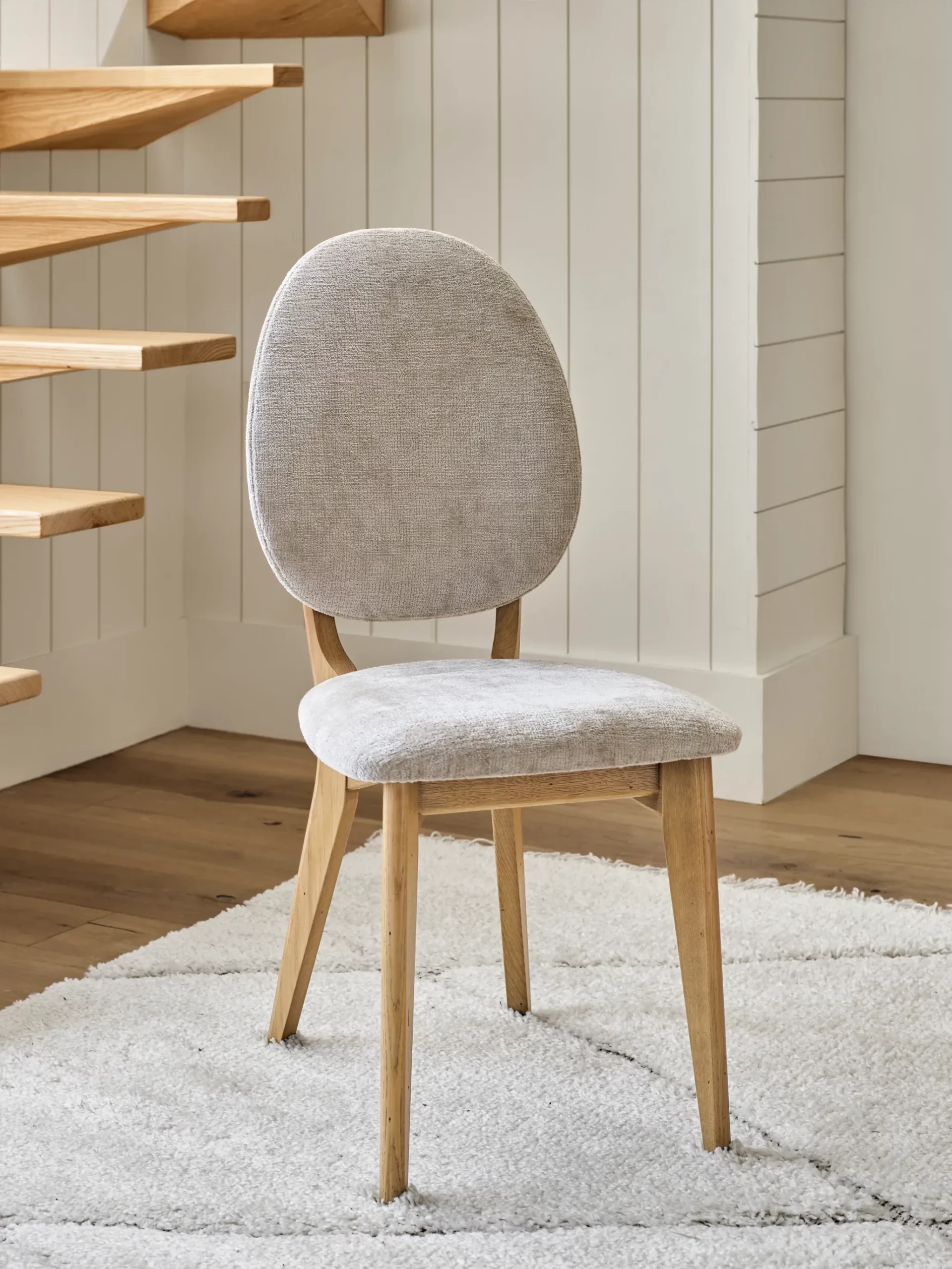 chaise médaillon en tissu clair sur tapis clair