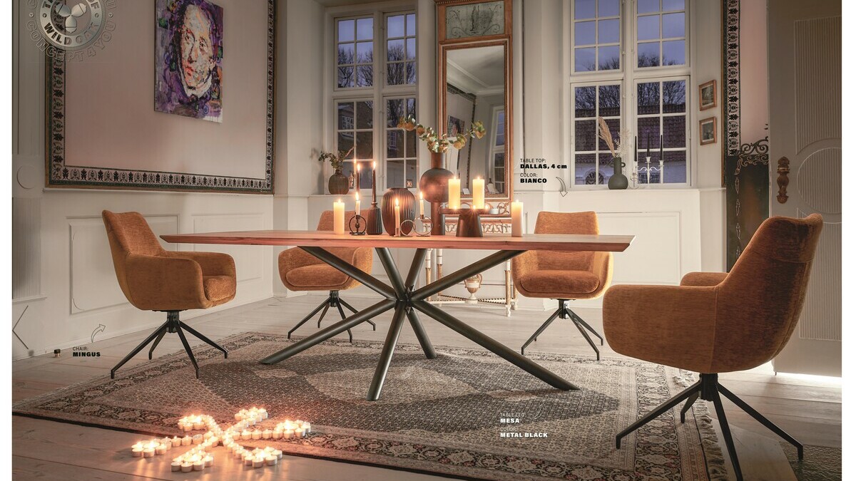 Fauteuil terracotta autour d'une table bois et metal avec des bougies et un tableau
