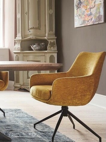 Chaise avec accoudoirs jaune autour d'une table bois sur tapis gris